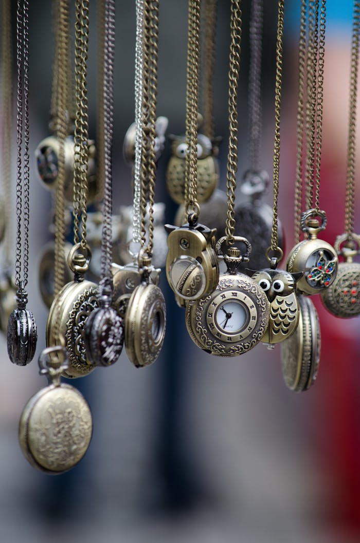A collection of ornate vintage pocket watches hanging beautifully from chains.